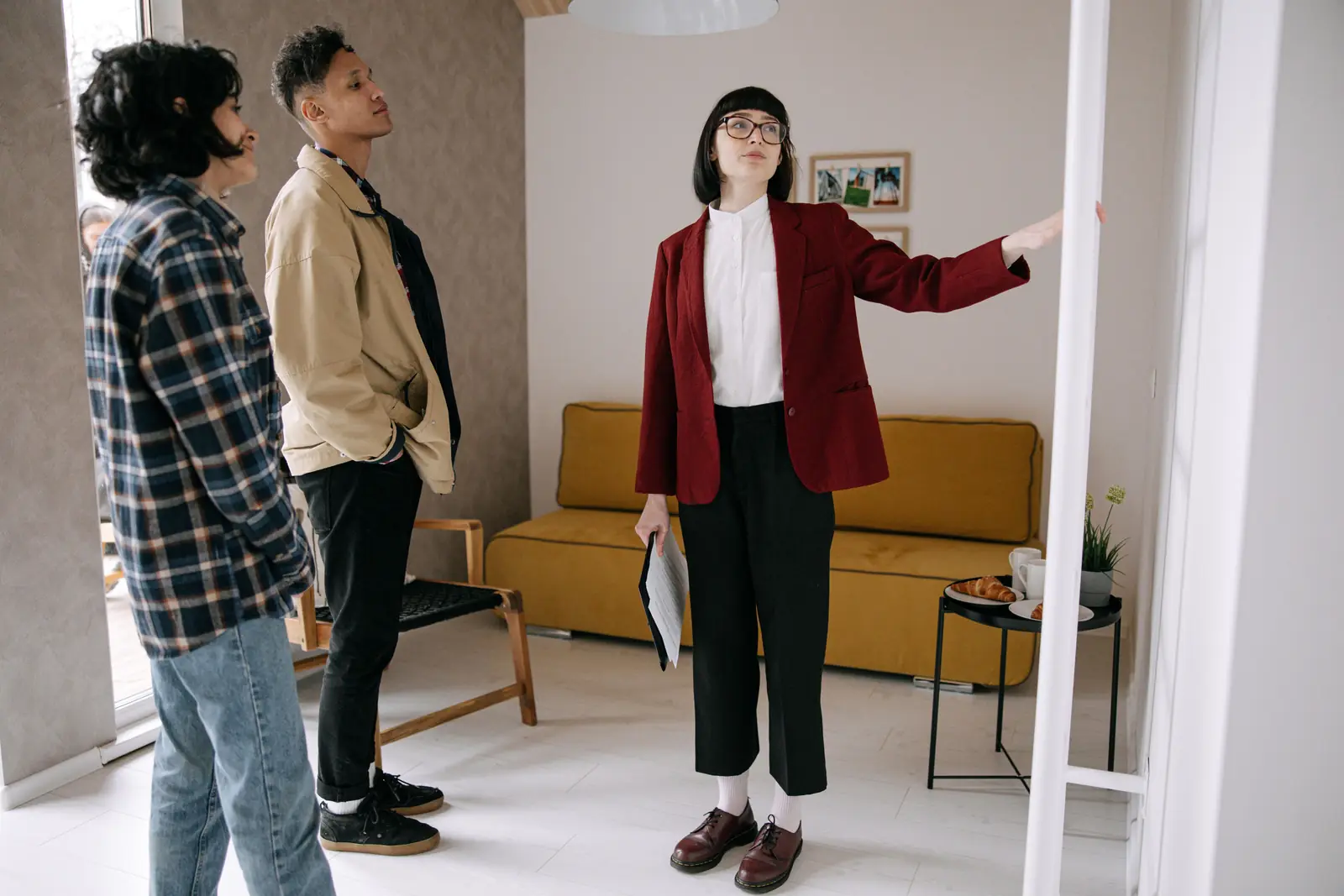 An agent showing two people around a furnished flat during a viewing.